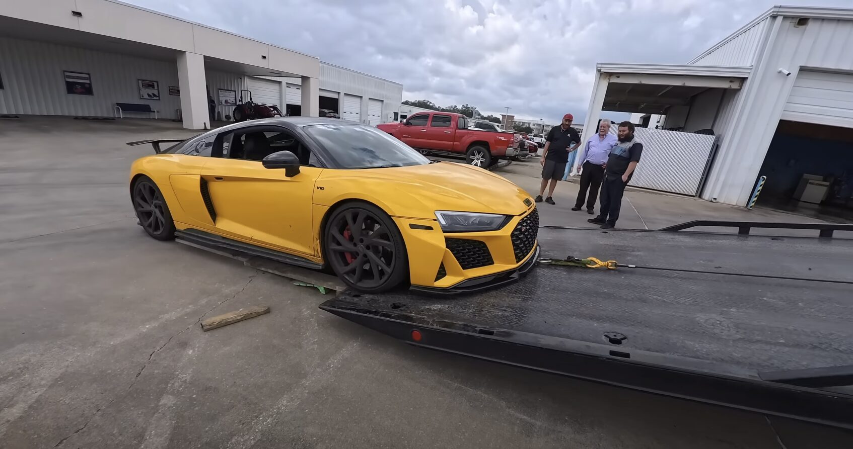 Professional flatbed towing for luxury vehicles Luxury car being loaded onto flatbed tow truck for safe transport